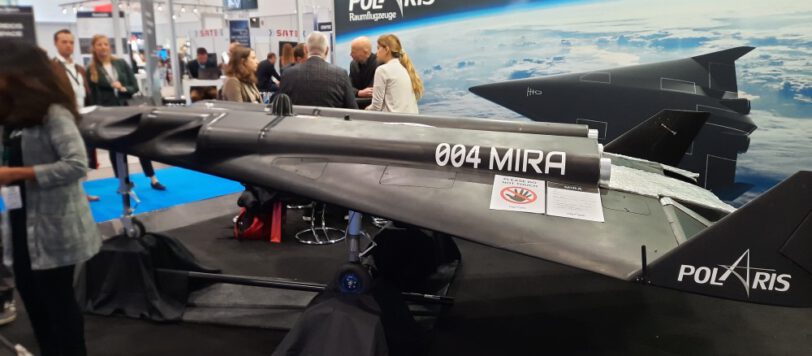 Photo of a black space plane model against the backdrop of a trade fair booth